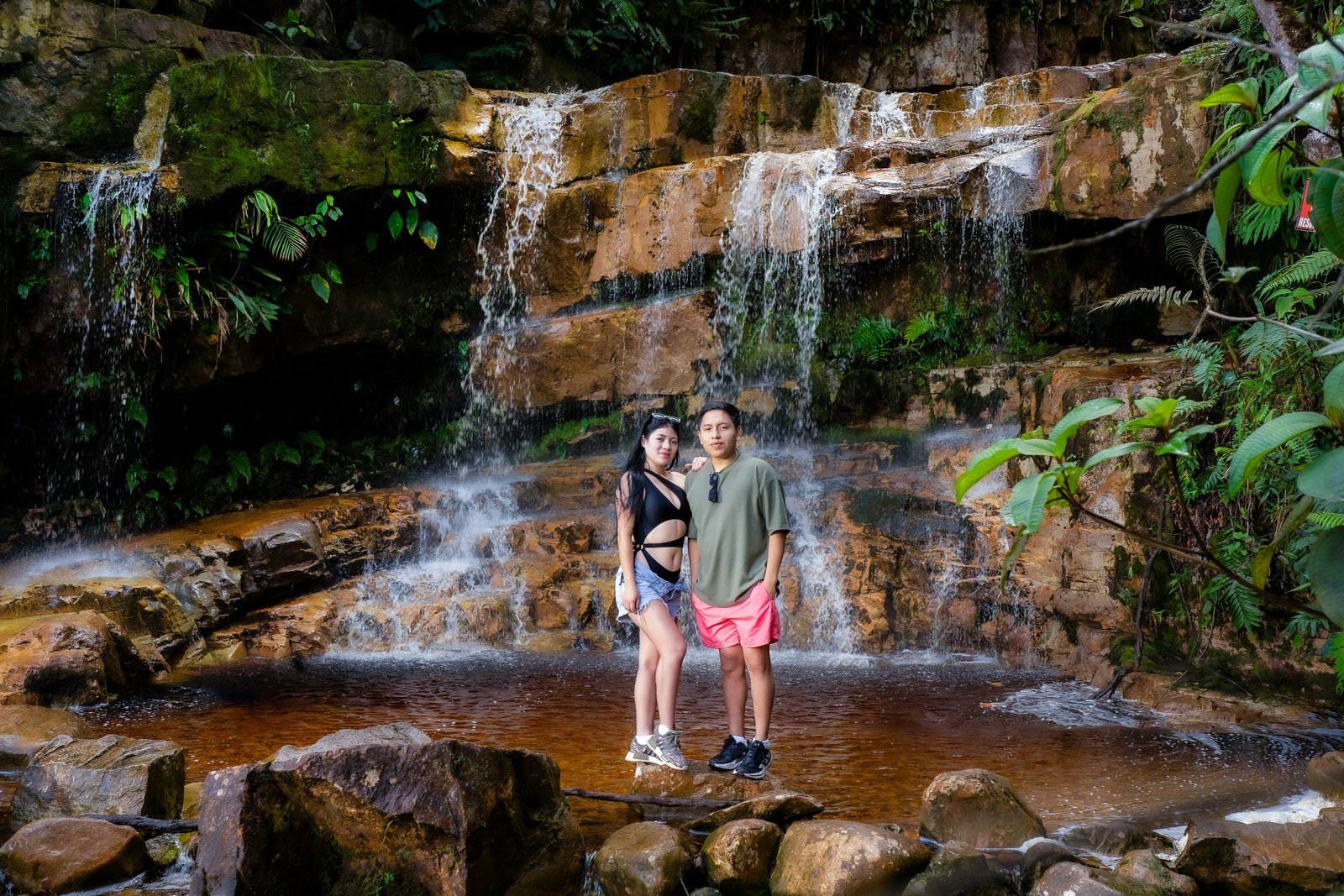 Visitantes frente a una cascada en Cascadas Coloradas