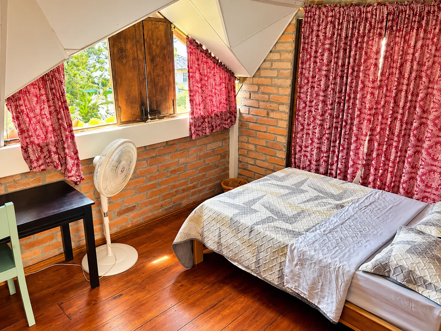 Habitación de Casa Leticia con cama, ventana y cortinas blancas