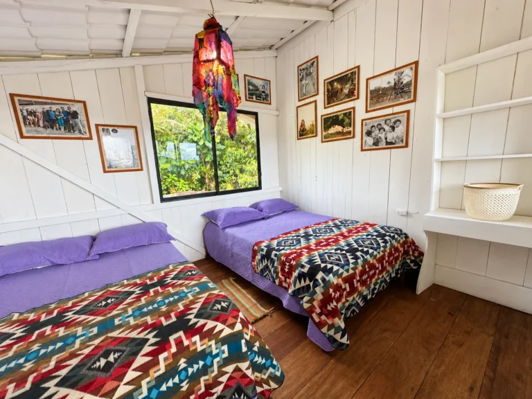 Habitación de Yajanua Centro Cultural con dos camas y textiles coloridos