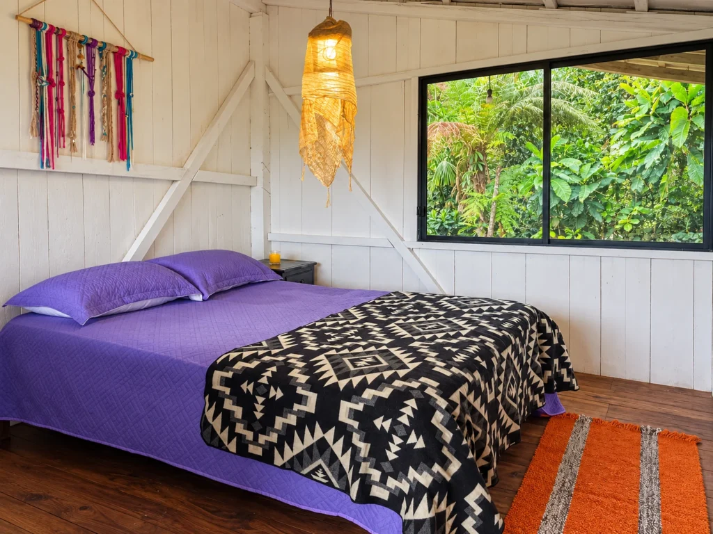 Habitación con cama doble y ventana al bosque en Yajanua Centro Cultural